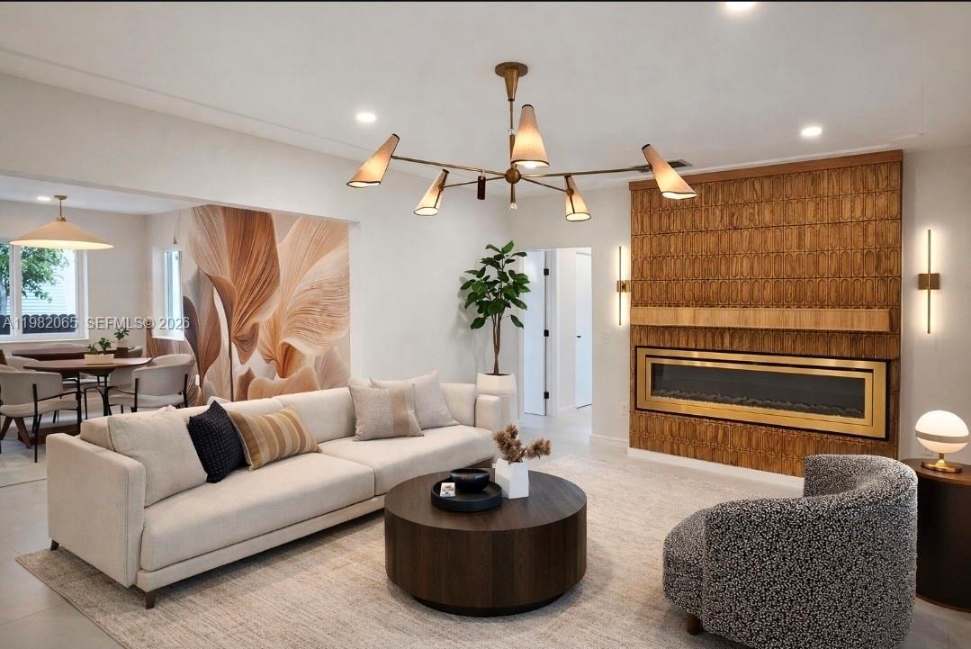 A living room features a textured wood fireplace, a modern chandelier, and a neutral sofa — 2365 SW 21st Ave, Miami FL 33145, MIAMI, FL