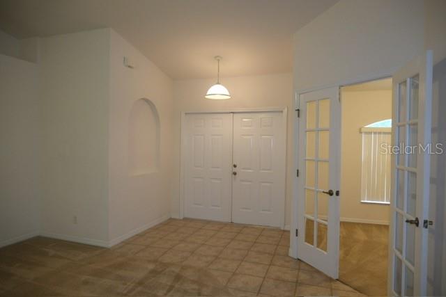 A room with tiled floors, a recessed wall niche, double doors, and French doors — 1430 SEAPORT STREET, NORTH PORT, FL