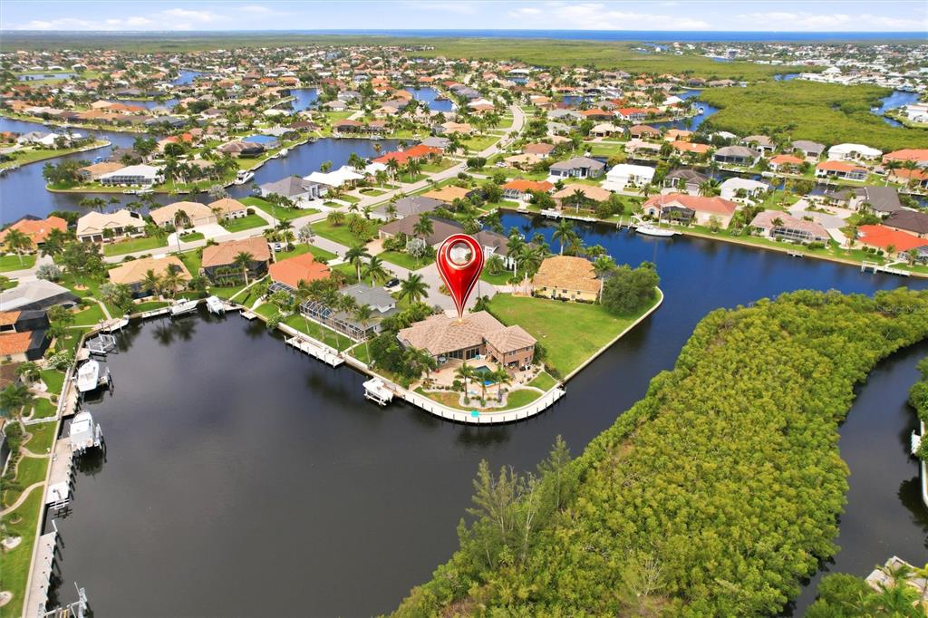 An aerial view shows a waterfront house with a pool on a canal-side lot — 3506 MARSALA COURT, PUNTA GORDA, FL