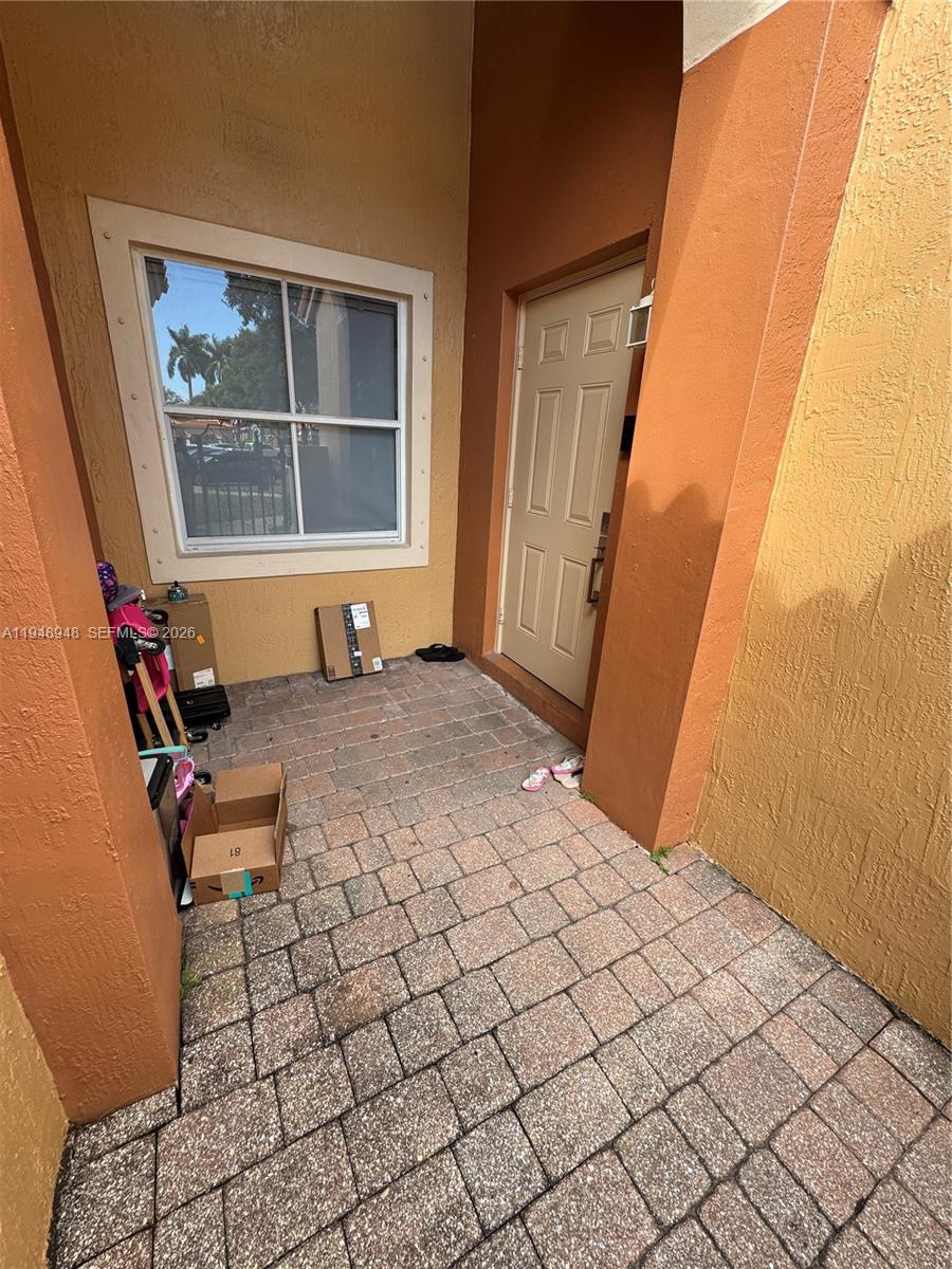 A paved entryway features a tan door, a window, and several cardboard boxes — 4957 Tradewinds Ter # 704, Dania Beach FL 33312, DANIA BEACH, FL