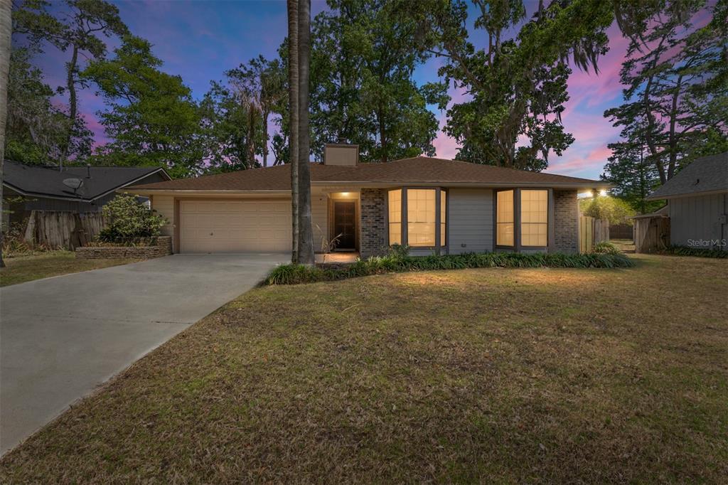 A single-story house with a two-car garage, brick accents, and two bay windows — 4363 NW 61ST TERRACE, GAINESVILLE, FL