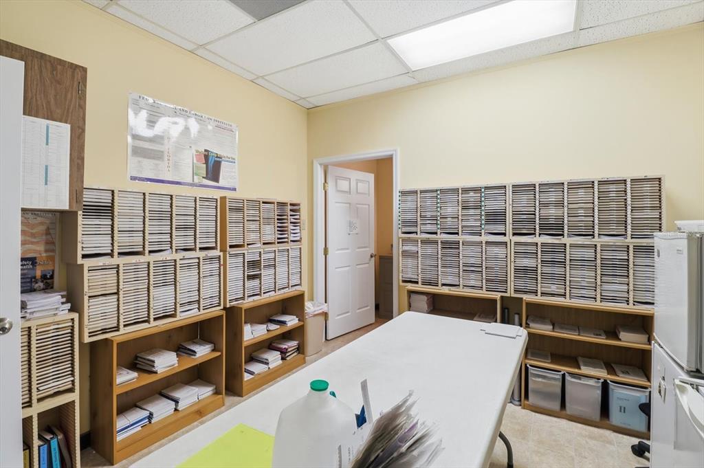 An office or storage room features numerous cubby shelves, a central table, and a doorway — 3380 E GULF TO LAKE HIGHWAY UNIT 17, INVERNESS, FL