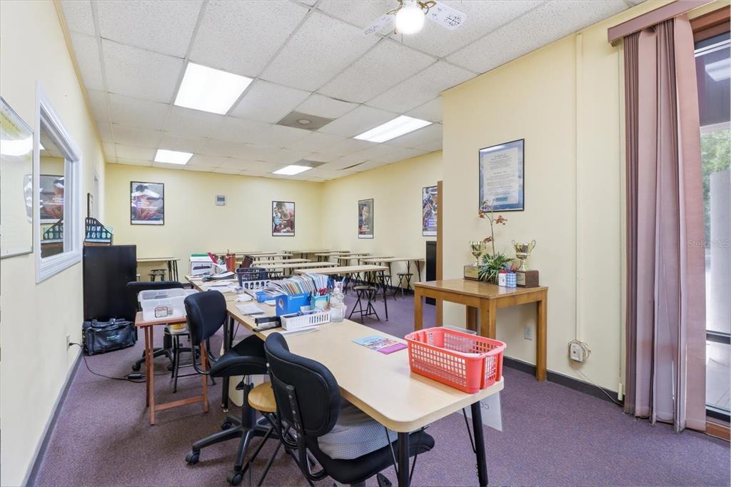 An office or classroom space features rows of desks, chairs, and fluorescent ceiling lights — 3380 E GULF TO LAKE HIGHWAY UNIT 17, INVERNESS, FL