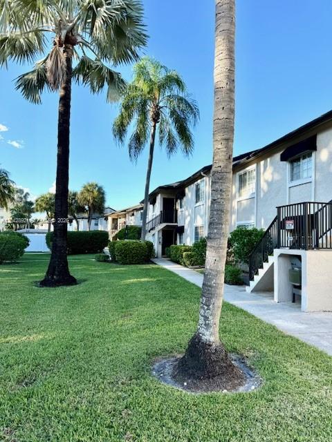 A multi-story apartment building with palm trees and a grassy lawn in the foreground — 4000 Crystal Lake Dr # 112, Deerfield Beach FL 33064, DEERFIELD BEACH, FL