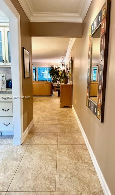 A tiled hallway leads from a kitchen toward a living area with a tan sofa — 4000 Crystal Lake Dr # 112, Deerfield Beach FL 33064, DEERFIELD BEACH, FL