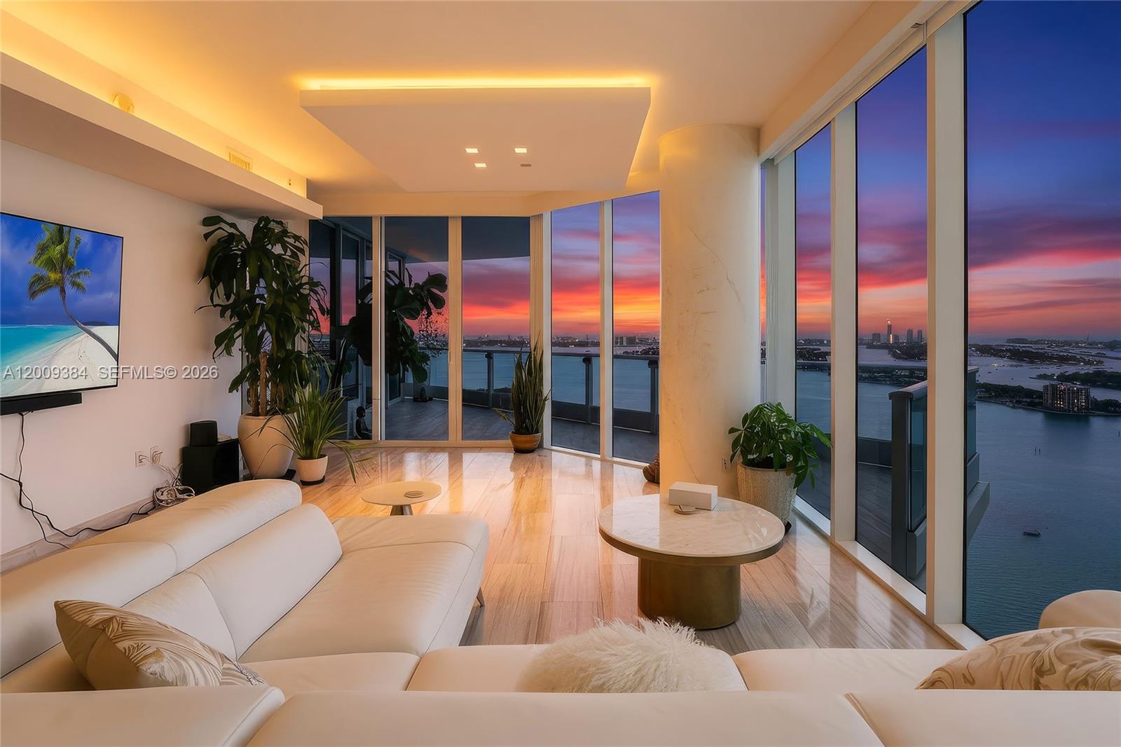 A modern living room features a white sectional sofa, marble floors, and floor-to-ceiling windows — 2020 N Bayshore Dr # 3902, Miami FL 33137, MIAMI, FL