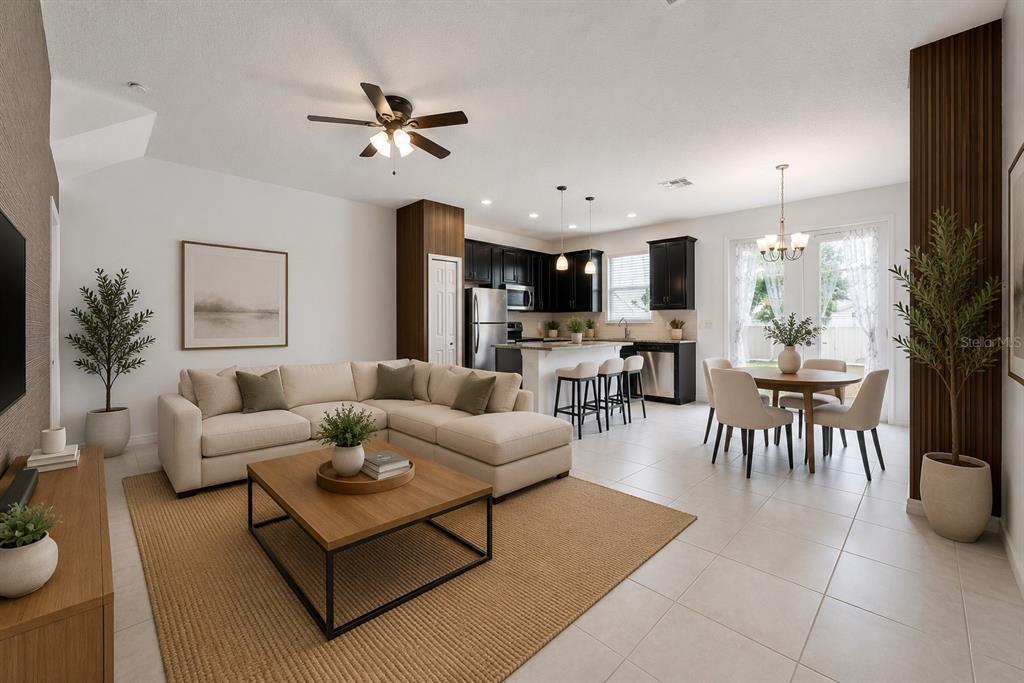 An open-concept living room and kitchen featuring a sectional sofa, dining area, and dark cabinetry — 2588 SEDGE GRASS WAY, ORLANDO, FL