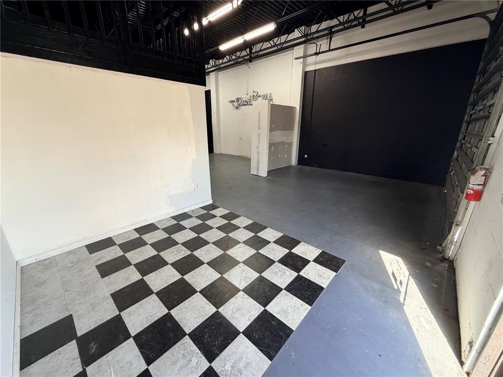 An interior view of a commercial space featuring a checkered floor and black accent wall — 6102 E ADAMO DRIVE, TAMPA, FL