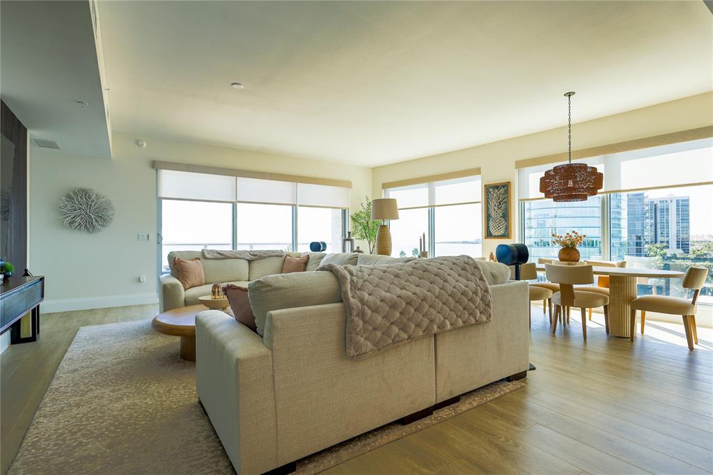 A living and dining area with light wood floors, neutral furniture, and floor-to-ceiling windows — 2910 W BARCELONA STREET UNIT 604, TAMPA, FL