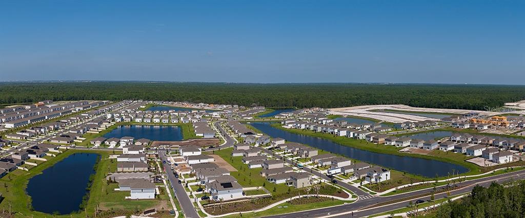 This aerial view shows a suburban residential neighborhood with several houses and retention ponds — 5410 CROWN POINT ROAD, KISSIMMEE, FL
