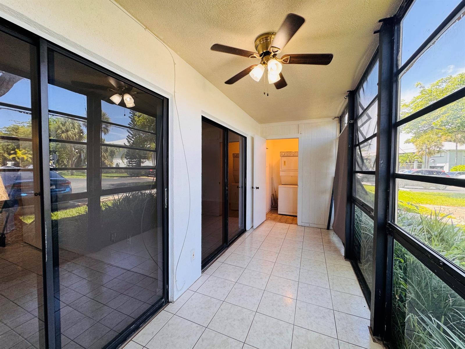 A tiled, screened-in porch features a ceiling fan and sliding glass doors leading indoors — 809 NE 199th Street # 7, Miami FL 33179, MIAMI, FL