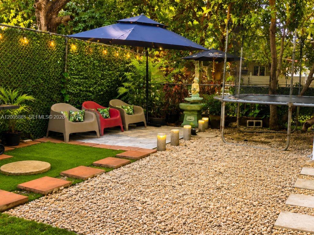 A two-story white house features a carport, a metal fence, and a gravel driveway — 265 NE 55th Ter # 1, Miami FL 33137, MIAMI, FL