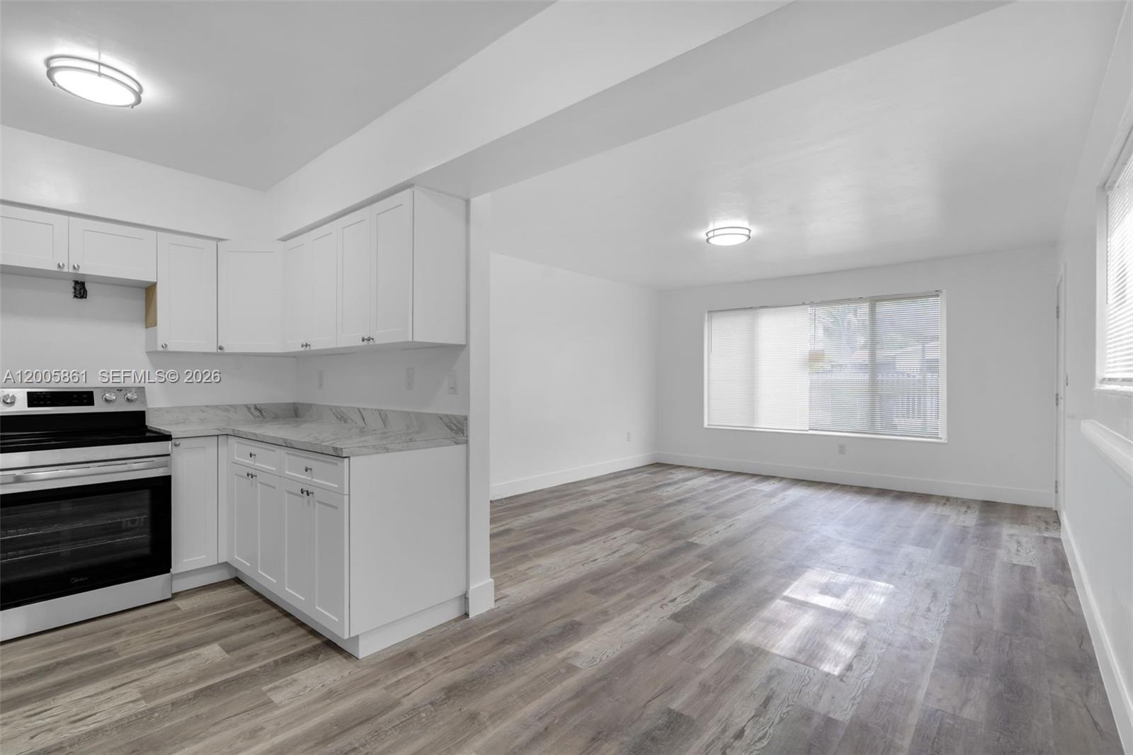 A white two-story building exterior features a light blue door and a wall-mounted fire extinguisher — 265 NE 55th Ter # 1, Miami FL 33137, MIAMI, FL