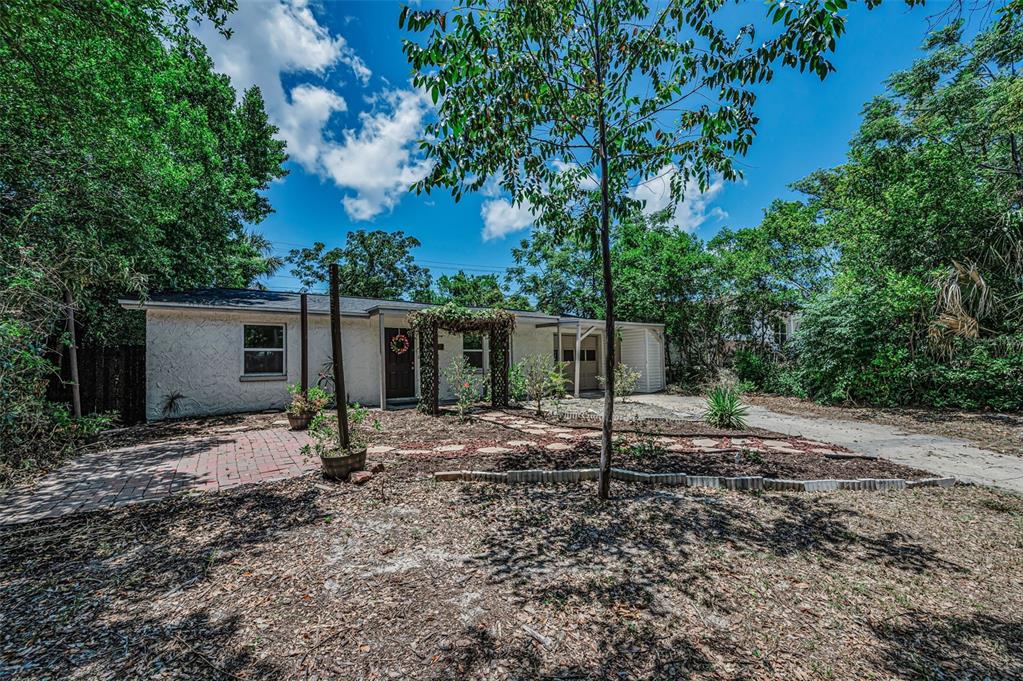 A single-story house with a white stucco exterior, a brick patio, and a wooden arbor — 4312 BEACON SQUARE DRIVE, HOLIDAY, FL