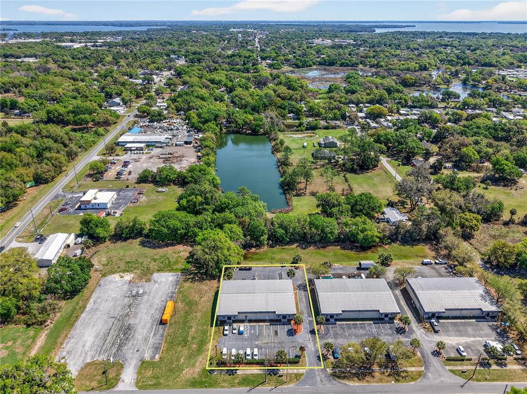 An aerial view shows three commercial warehouse buildings with parking lots and a nearby pond — 300 RICHEY ROAD, LEESBURG, FL
