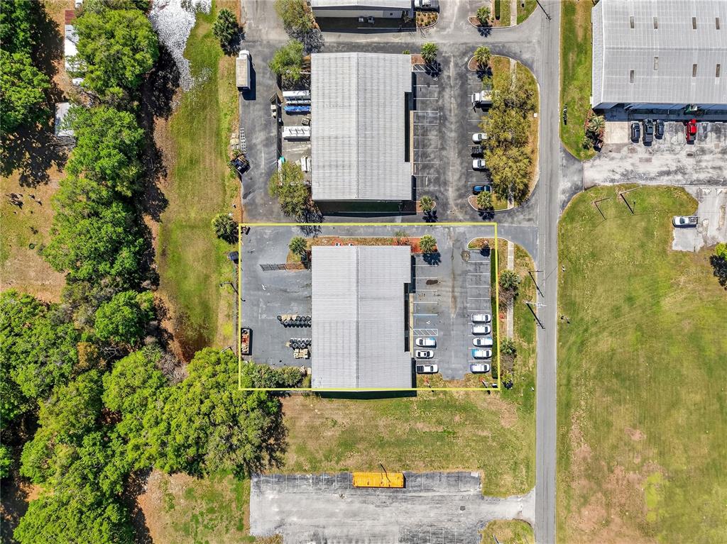 An aerial view shows a commercial building with a parking lot outlined in yellow — 300 RICHEY ROAD, LEESBURG, FL