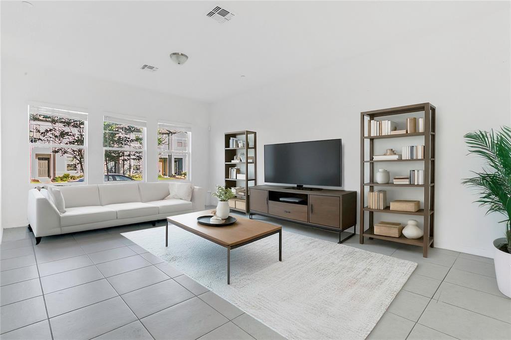 A living room features a white sofa, wood media console, two bookshelves, and tile flooring — 3335 AZOLLA STREET, ORLANDO, FL