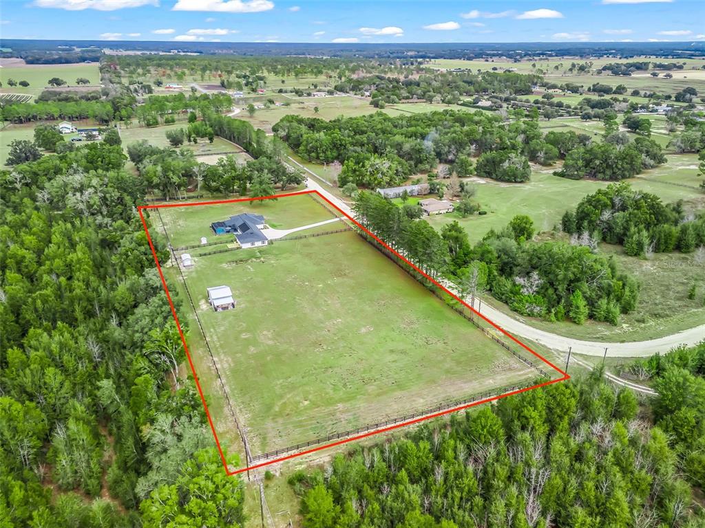 An aerial view shows a fenced rectangular property with a house and outbuilding — 6570 SE 175TH COURT, MORRISTON, FL