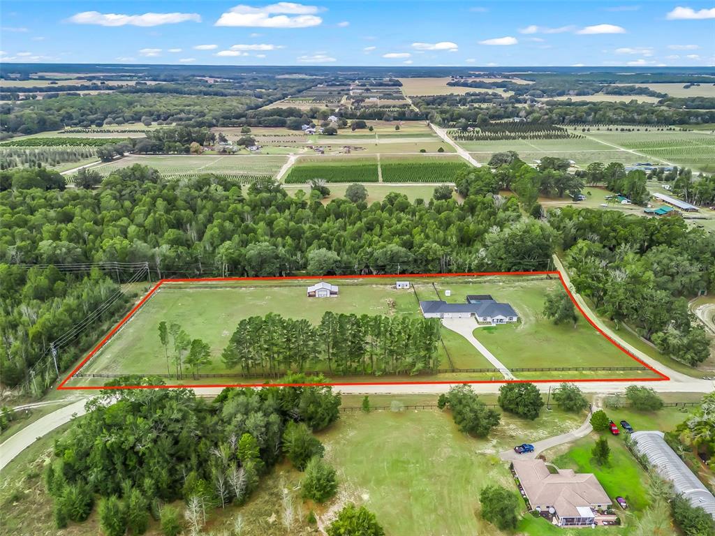 An aerial view shows a house and a detached building on a fenced rural lot — 6570 SE 175TH COURT, MORRISTON, FL