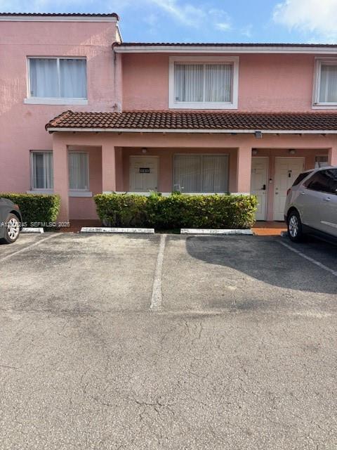 A two-story pink building with a covered walkway and parking spaces in front — 8019 Lake Dr # 103, Doral FL 33166, DORAL, FL