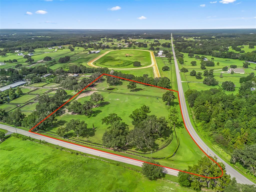 An aerial view shows a fenced, grassy plot of land bordered by two roads — TBD NW 110TH AVE, OCALA, FL