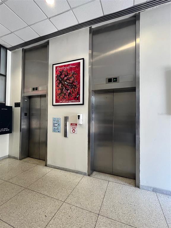 An elevator lobby with two stainless steel elevator doors and a framed piece of art — 1509 LOPEZ LANDRON, SAN JUAN, PR
