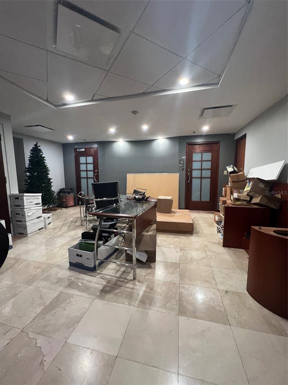 An office space with tile flooring, a glass-topped desk, and two wooden doors — 1509 LOPEZ LANDRON, SAN JUAN, PR