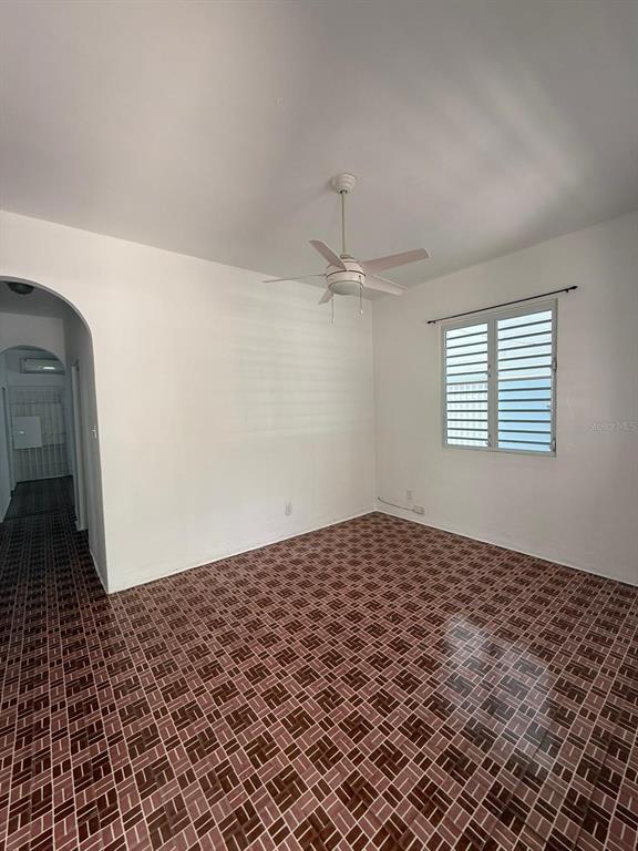 An empty room features white walls, a ceiling fan, and a brown patterned tile floor — 513 BARBE STREET UNIT 101, SAN JUAN, PR