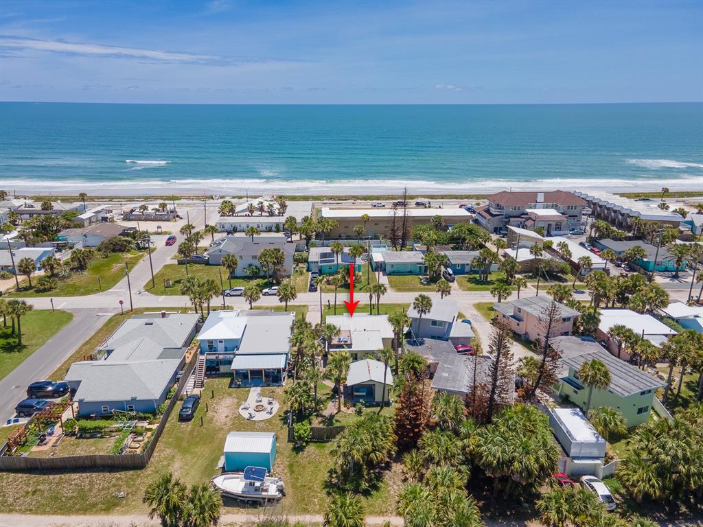 An aerial view shows a coastal neighborhood with houses, palm trees, and the ocean beyond — 1208 S CENTRAL AVENUE, FLAGLER BEACH, FL