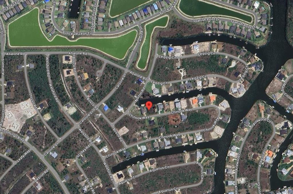 This is an aerial map view of a residential neighborhood with houses and canals — 15068 CHINOOK WAY, PORT CHARLOTTE, FL
