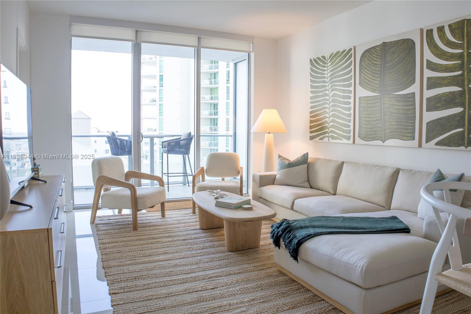 A modern living room features a beige sectional, two accent chairs, and a balcony view — 1300 Brickell Bay Dr # 1608, Miami FL 33131, MIAMI, FL