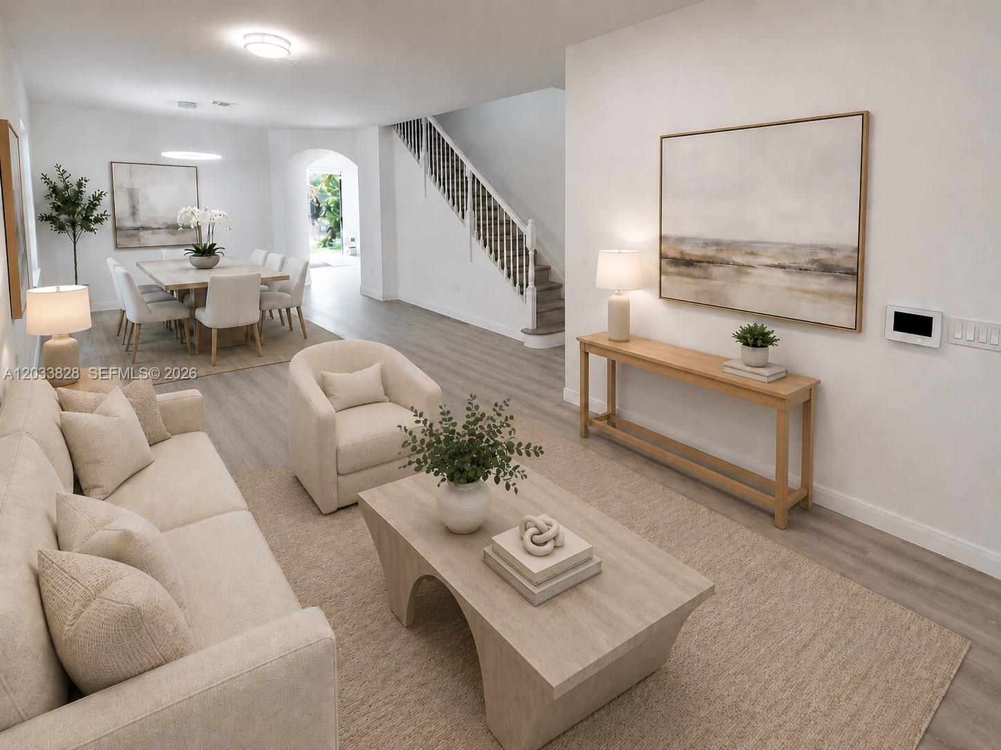 A bright living and dining area features light wood flooring, neutral furniture, and a staircase — 8858 NW 101st Pl, Doral FL 33178, DORAL, FL