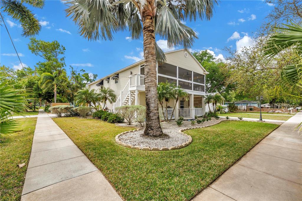 A two-story house with a screened-in porch and exterior stairs sits on a corner lot — 786 59TH AVENUE NE, ST PETERSBURG, FL