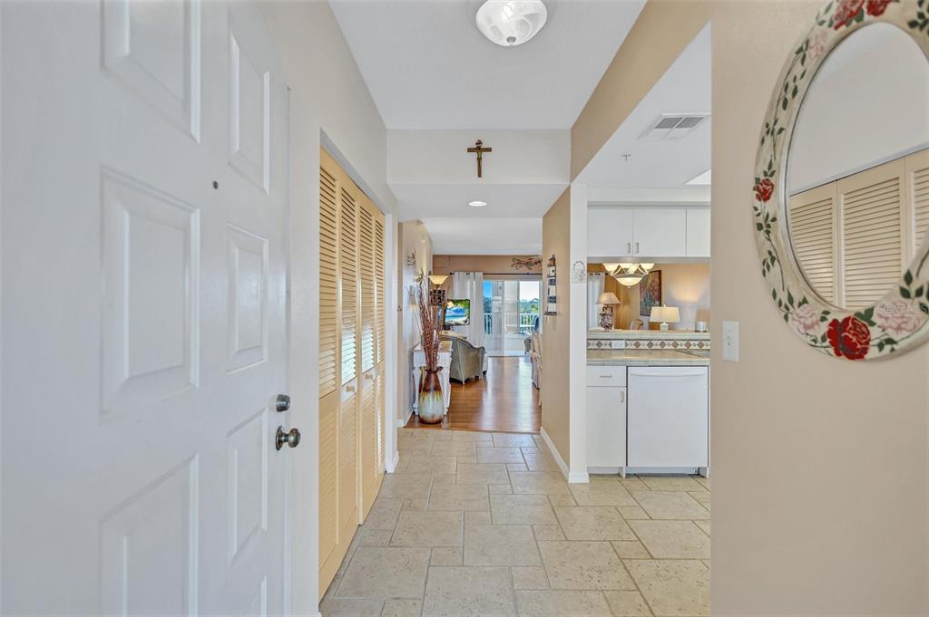 A tiled entryway leads past a closet and kitchen toward a living area with balcony access — 6475 SHORELINE DRIVE UNIT 5102, ST PETERSBURG, FL