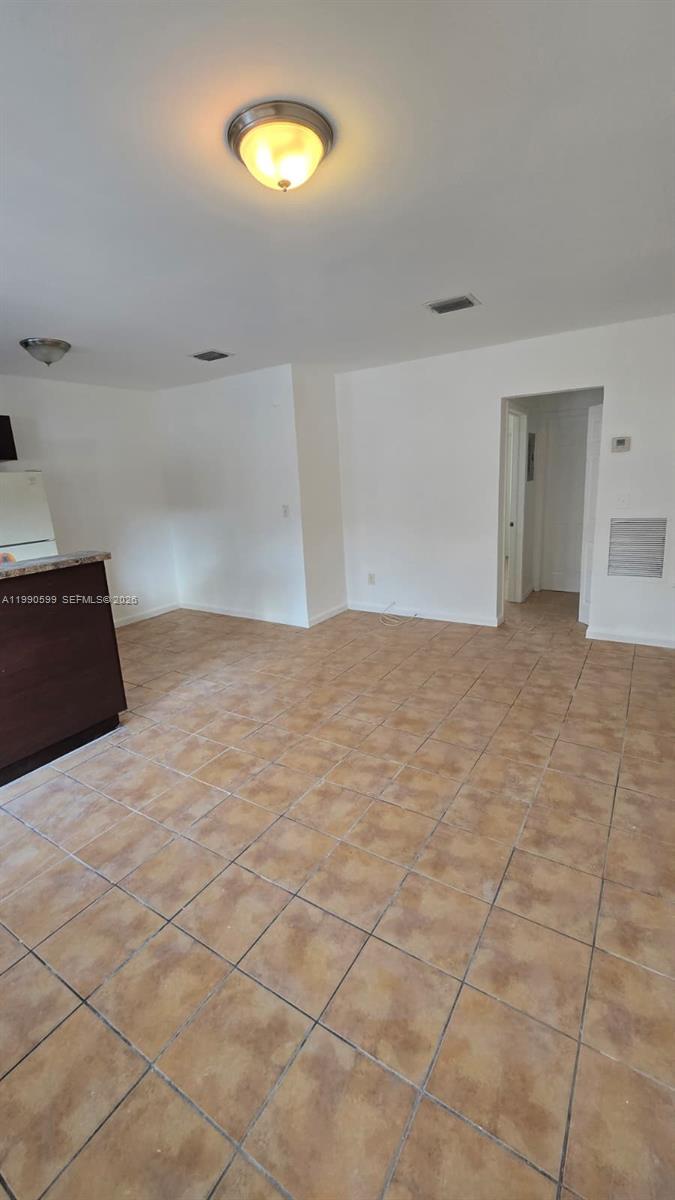 An interior view shows a room with beige tile flooring, white walls, and a ceiling light — 16131 NE 19th Pl # 3, North Miami Beach FL 33162, NORTH MIAMI BEACH, FL