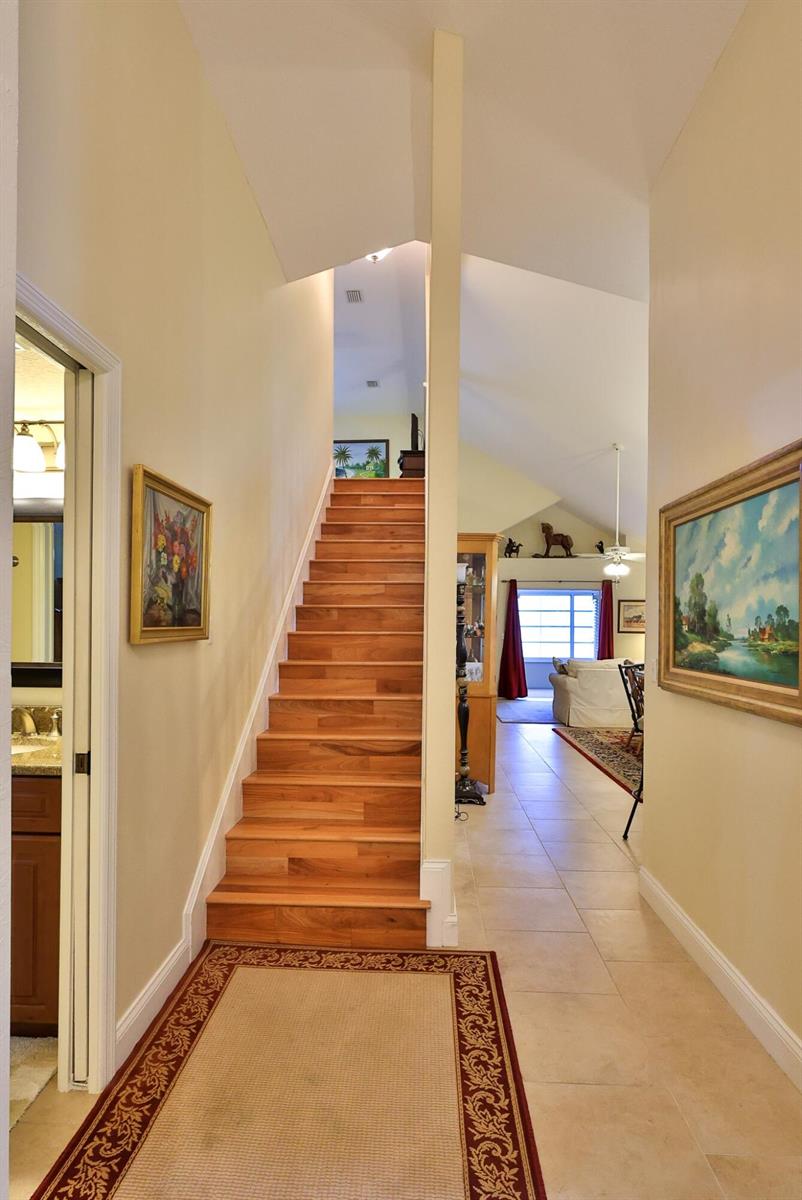 A hallway features a wooden staircase, tile flooring, and a view into a living area — 234 Braeburn Circle, FL 32114, FL