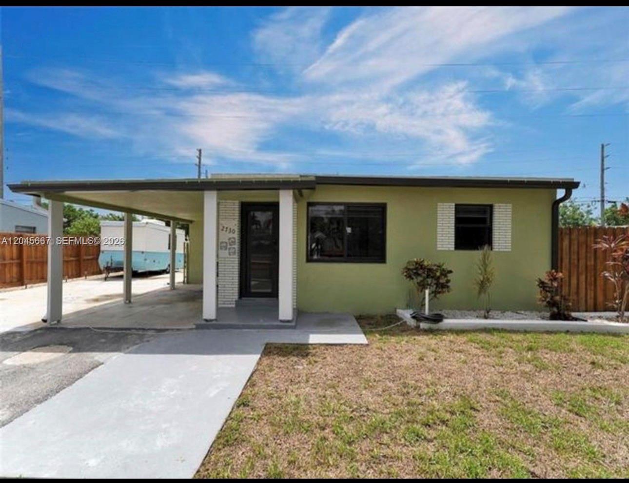 A single-story house with a green exterior, a front carport, and a concrete walkway — 2730 NE 16th Ave # 0, Pompano Beach FL 33064, POMPANO BEACH, FL