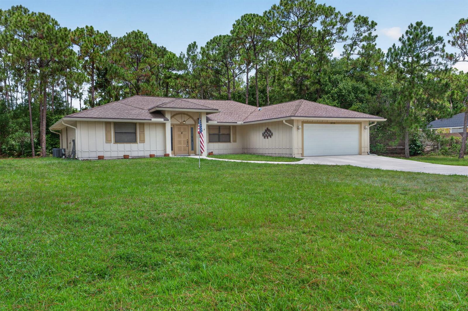 A single-story house with beige vertical siding, a brown shingled roof, and a two-car garage — 16735 Alexander Run, Jupiter FL 33478, JUPITER, FL