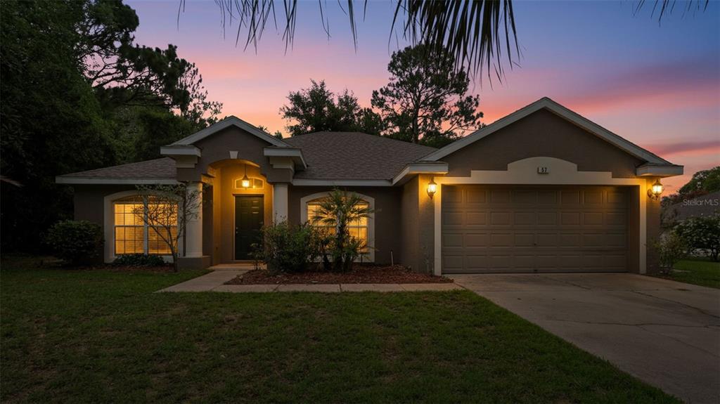 A single-story house with a brown exterior, a two-car garage, and a covered front entryway — 57 PINE DRIVE, HOMOSASSA, FL