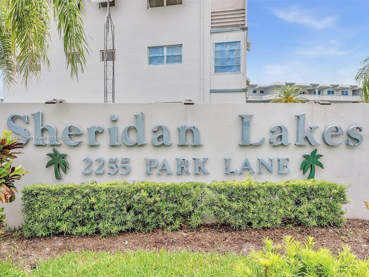 A sign for Sheridan Lakes stands in front of a multi-story apartment building — 2300 Park Ln # 105, Hollywood FL 33021, HOLLYWOOD, FL