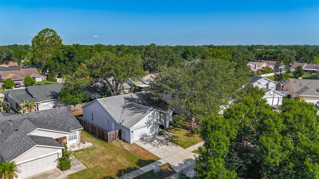 An aerial view of a suburban neighborhood featuring single-family homes with gray roofs and trees — 13436 SILVERCREEK DRIVE, RIVERVIEW, FL