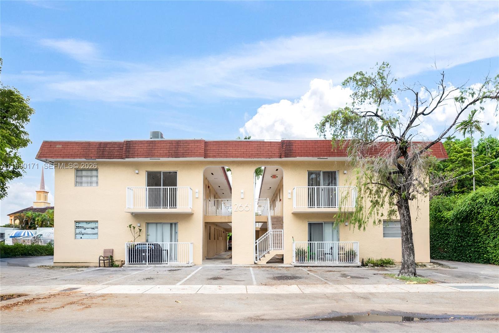 A two-story, yellow stucco apartment building features a red roof and exterior parking spaces — 2661 SW 11th St # 8, Miami FL 33135, MIAMI, FL