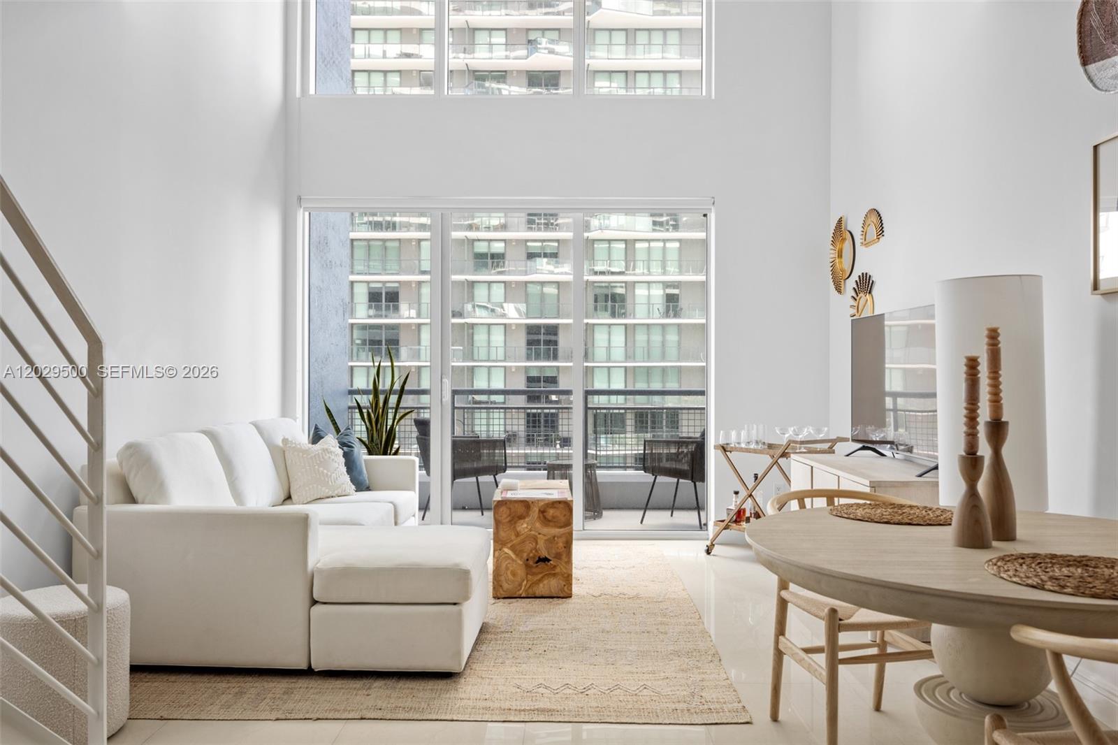A bright living room features a white sectional sofa, wooden coffee table, and floor-to-ceiling windows — 60 SW 13th St # 3414, Miami FL 33130, MIAMI, FL