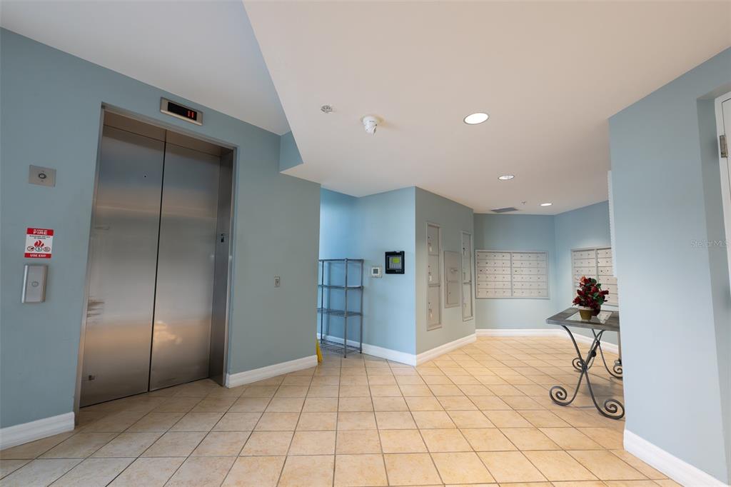 An elevator lobby features light blue walls, tiled floors, and a bank of mailboxes — 3414 HANCOCK BRIDGE PARKWAY UNIT 505, NORTH FORT MYERS, FL