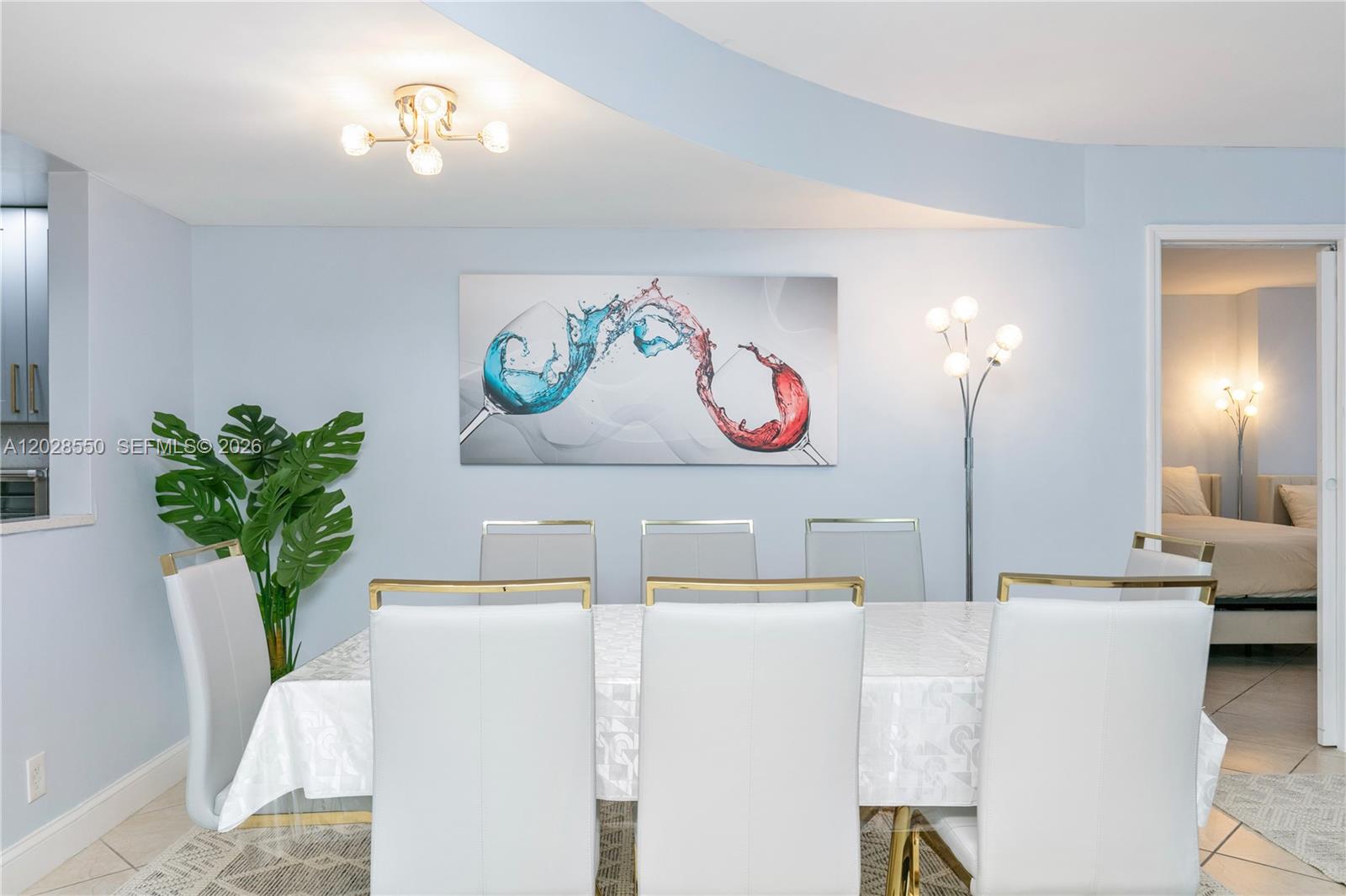 A dining room features a white table, six chairs, and abstract wine glass wall art — 2401 S Ocean Dr # 404, Hollywood FL 33019, HOLLYWOOD, FL