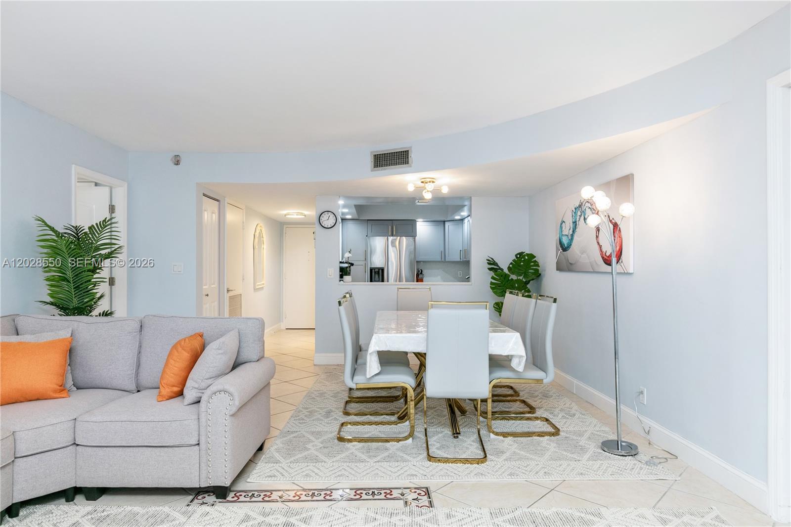 A living and dining area features a grey sofa, a dining set, and light-colored walls — 2401 S Ocean Dr # 404, Hollywood FL 33019, HOLLYWOOD, FL