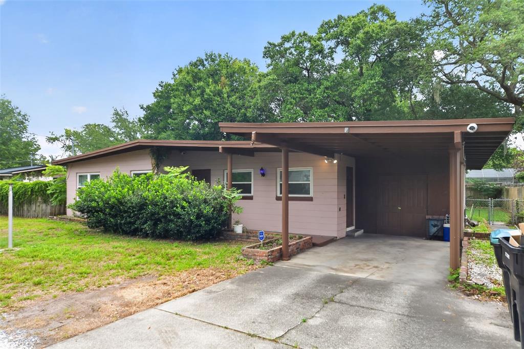 A single-story house with a carport, brown siding, and a large front yard — 2615 PEEL AVENUE, ORLANDO, FL