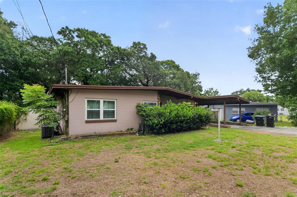 A single-story house with tan siding, a carport, and a large front yard with trees — 2615 PEEL AVENUE, ORLANDO, FL