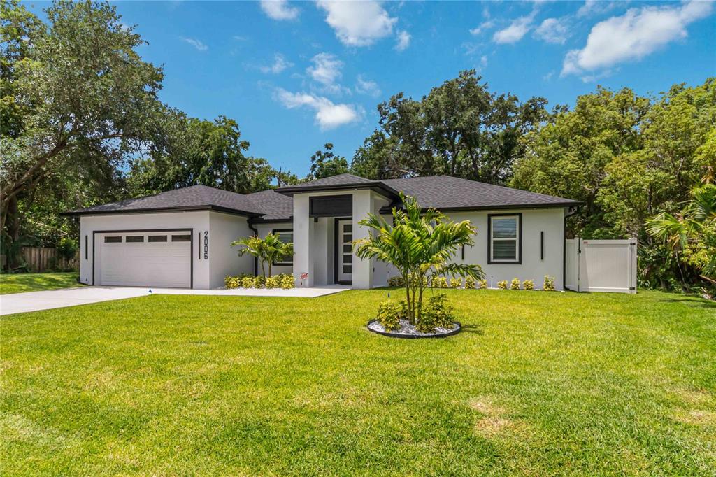 A single-story house with a white exterior, black trim, a two-car garage, and a lawn — 2006 WILLIAMS AVENUE, SANFORD, FL