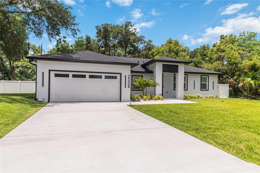 A single-story house with a white exterior, black trim, and a concrete driveway — 2006 WILLIAMS AVENUE, SANFORD, FL